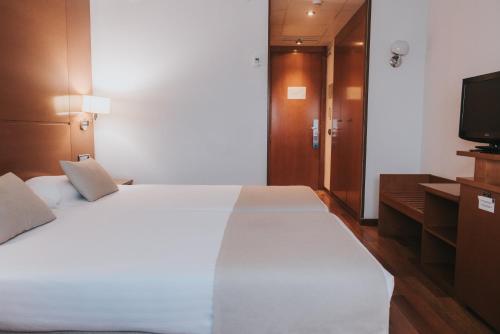 1 dormitorio con 1 cama blanca grande y TV en Allegro Murcia Azarbe, en Murcia