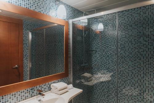 
a bathroom with a sink, mirror, and bathtub at Hotel Azarbe in Murcia
