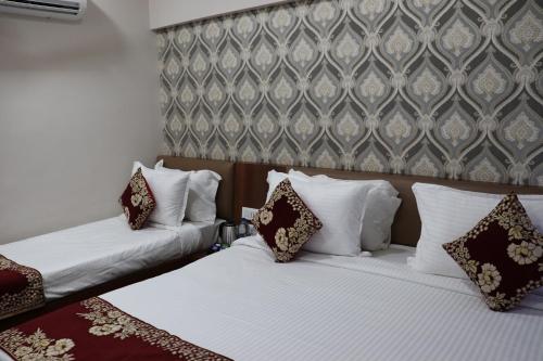 two beds in a hotel room with pillows at Hotel Ajmer Tower in Ajmer