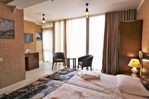 um quarto de hotel com uma cama, uma mesa e cadeiras em Hotel Liberty Theatre em Tbilisi