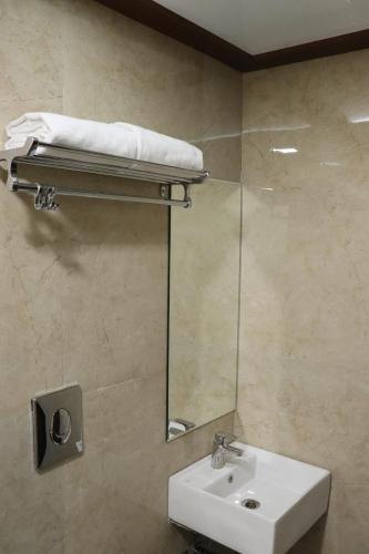 a bathroom with a sink and a mirror at Hotel Ajmer Tower in Ajmer