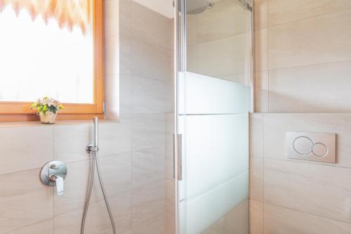 a shower with a glass door in a bathroom at Hotel Erna in Colle Isarco
