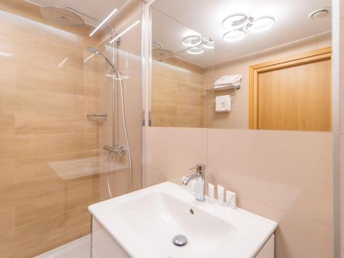 a bathroom with a white sink and a shower at Apartament Prywatny Seaside Park Rackiewicz in Kołobrzeg