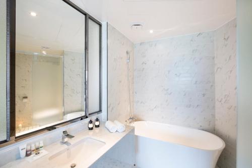 a white bathroom with a sink and a mirror at Brown Dot Hotel Jinju in Jinju