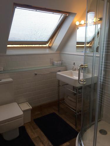 uma casa de banho com um lavatório e um chuveiro com uma janela em Off The Hill B&B em Isleornsay
