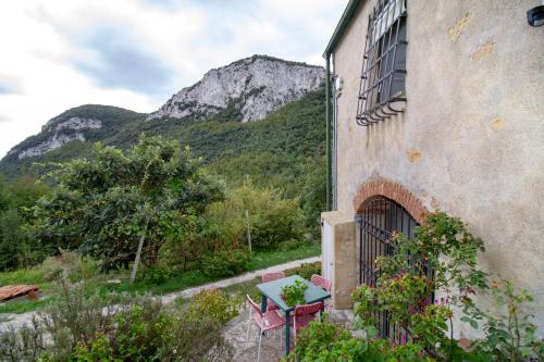 een tafel en stoelen buiten een gebouw met een berg bij Casa dei Templari in Finale Ligure