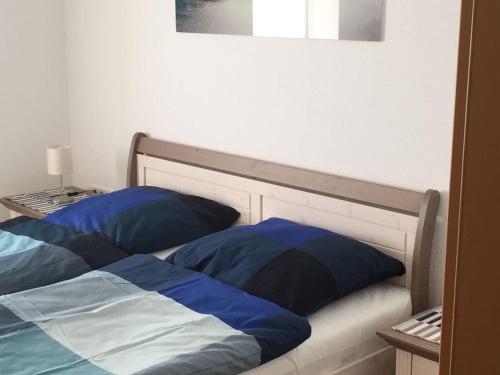 Bett mit blauen und weißen Kissen in einem Zimmer in der Unterkunft Ferienwohnung Orthsee in Hohen Wangelin