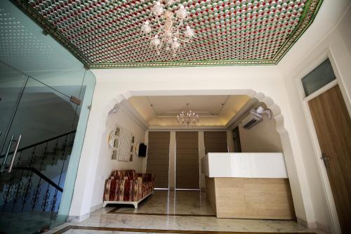 Cette chambre est dotée d'un plafond avec un lustre. dans l'établissement Hotel Ratangarh Palace, à Jaipur