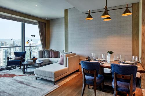 a living room with a couch and a table with chairs at K11 ARTUS in Hong Kong