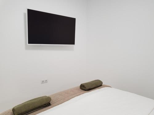 a bed with two pillows and a tv on a wall at Villa del Mar Esquinzo Jandia Fuerteventura in Playa Jandia