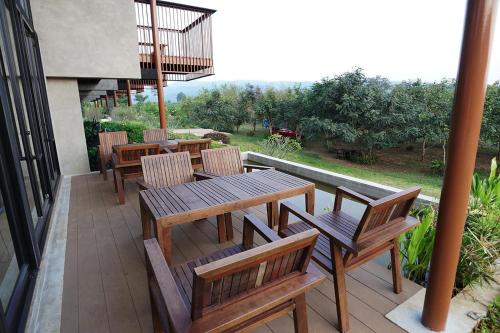 a wooden table and chairs on a patio at Hug Jang Loei Garden & Resort in Ban Na Dan