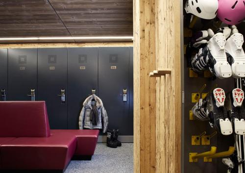 a locker room with a red bench and helmets at Hotel Tirol in Ischgl