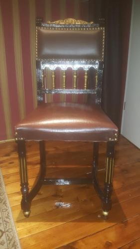 a brown leather chair sitting on top of a wooden floor at Gästehaus Mama in Rust