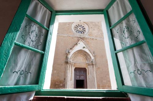 a view through a window of a building at Foresteria del Teatro Povero in Monticchiello