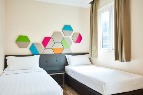 two beds sitting next to each other in a room at ibis budget Singapore Emerald in Singapore