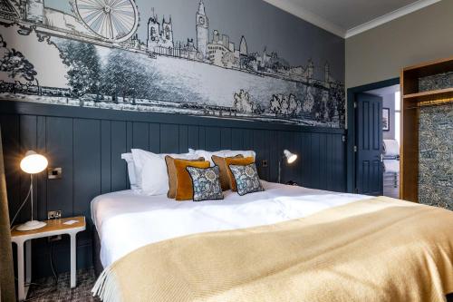 a bedroom with a large white bed with orange pillows at The Brook Green Hotel in London