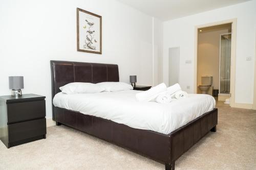 a bedroom with a large bed with two towels on it at Serviced Apartment In Liverpool City Centre - Free Parking - Balcony - by Happy Days in Liverpool