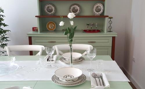 a dining room table with a vase of flowers on it at Metro Suites in Tirana