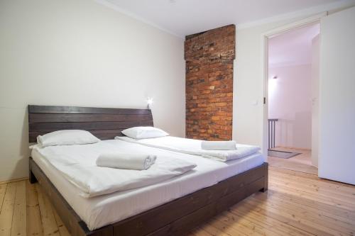 - un grand lit dans une chambre dotée d'un mur en briques dans l'établissement Dream Stay - Bright 2-Bedroom 2-Floor Old Town Apartment, à Tallinn