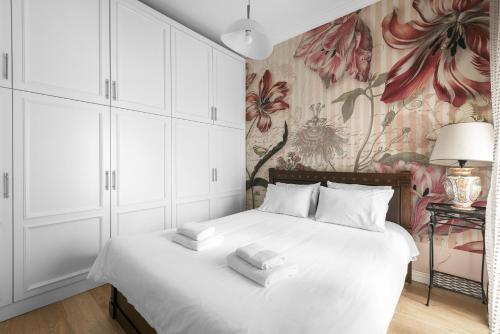 sypialnia z białym łóżkiem i tapetą w kwiaty w obiekcie Aristotelous Grand View by Luxlikehome w Salonikach