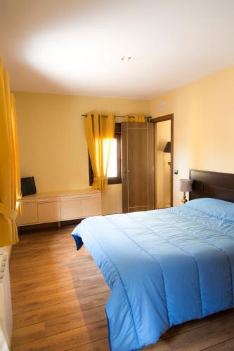 a bedroom with a blue bed and a window at Apartamentos "Casa Rural de Aldea" in Aldea del Fresno
