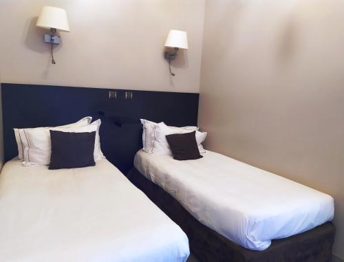 two beds sitting next to each other in a room at Best Western Central Hotel in Tours