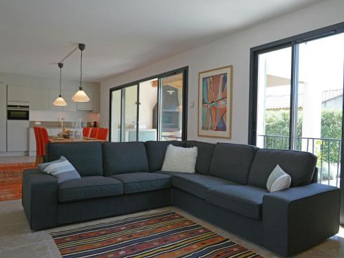 a living room with a blue couch and a kitchen at Superb villa with heated pool in Malauc ne in Malaucène