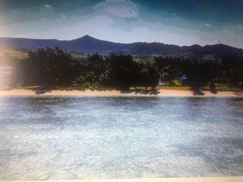 a body of water with trees and mountains in the background at Khesha’s Villa in Riambel
