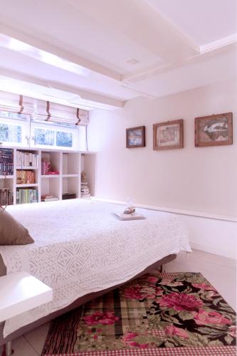 a white bedroom with a large bed and a rug at Cozy Canal Studio in Amsterdam