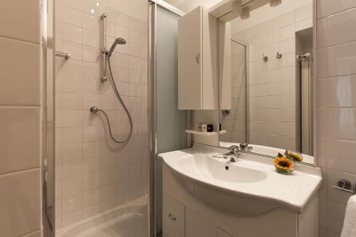 biała łazienka z umywalką i prysznicem w obiekcie Harry's Bar Trevi Luxury Apartments - Spagna w Rzymie