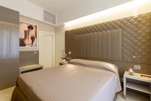 a bedroom with a bed and a painting on the wall at Harry's Bar Trevi Luxury Apartments - Spagna in Rome