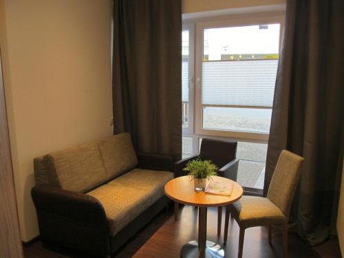 a living room with a couch and a table and a window at Zum Treppche Hotel Garni in Gladenbach