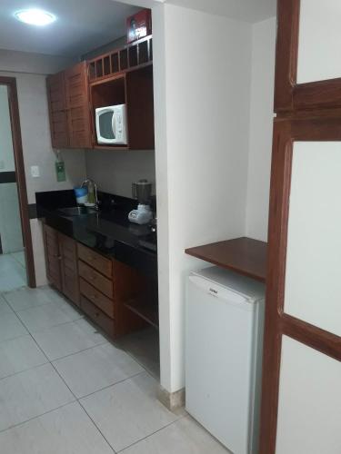 a small kitchen with a counter and a refrigerator at Mar do Cabo Branco Residence in João Pessoa