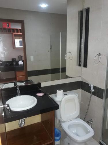 a bathroom with a toilet and a sink at Mar do Cabo Branco Residence in João Pessoa