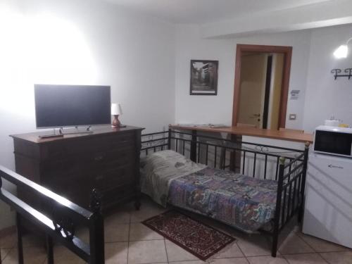 1 dormitorio con cuna y TV en Piazza Castello, en Candelo