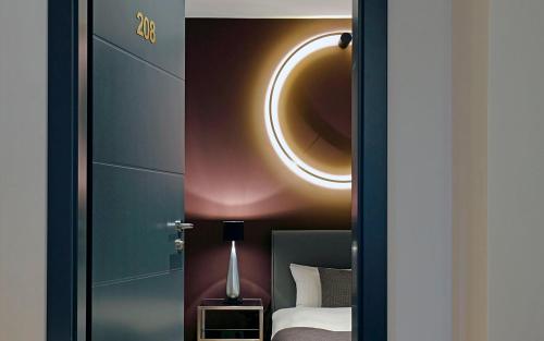 a bedroom with a bed and a round mirror at Patentkrug Design Hotel in Oldenburg