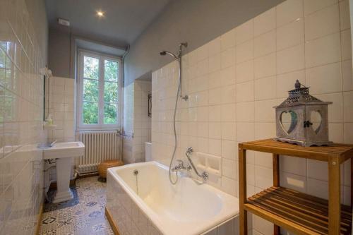 een badkamer met een ligbad en een wastafel bij Villa des Mimosas in Muzillac