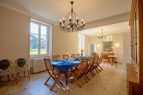 une salle à manger avec une table, des chaises et un lustre dans l'établissement Villa des Mimosas, à Muzillac