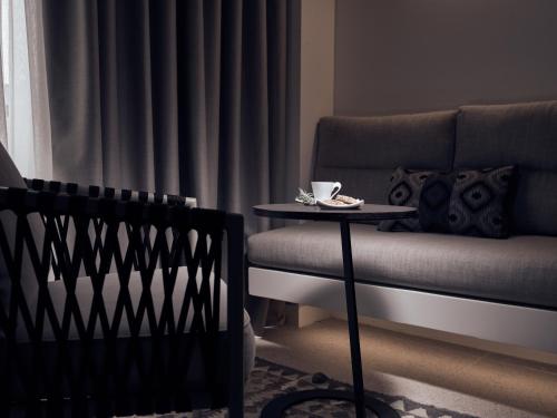 a living room with a couch and a table with a cup on it at Contessina Suites & Spa - Adults Only in Tsilivi