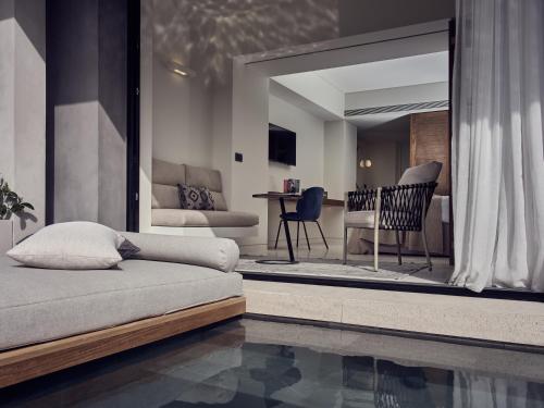 a living room with a bed and a dining room at Contessina Suites & Spa - Adults Only in Tsilivi