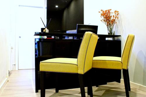 a desk with two yellow chairs in front of a desk at NOX Paddington in London
