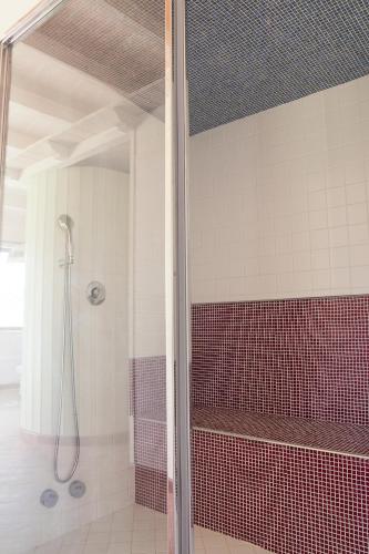 a bathroom with a shower with red and white tiles at Le Querce di Cota in Troina