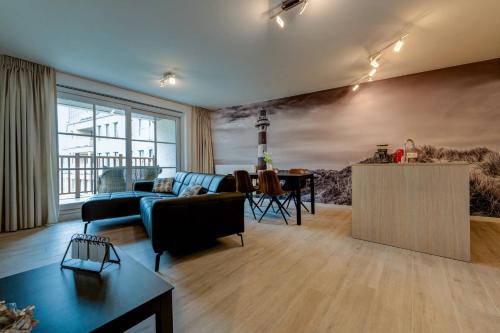 een woonkamer met een blauwe bank en een tafel bij Jef in Nieuwpoort