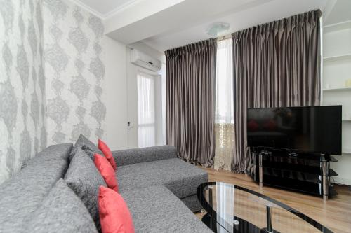 a living room with a couch and a television at ERA RENT Apartments in Chişinău
