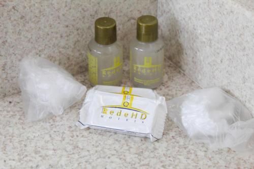two bottles of alcohol and a bag on a counter at Ônix Hotel in Assis