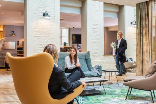 a group of people sitting in chairs in a lobby at Aparthotel Adagio Lille Centre Grand Place in Lille