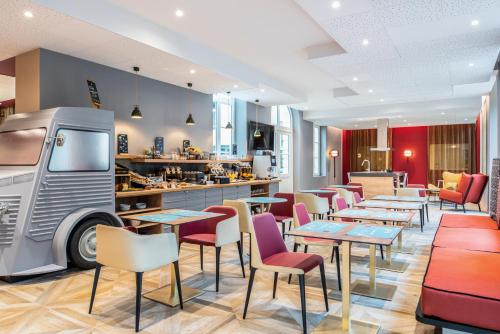 a restaurant with tables and chairs and a truck at Aparthotel Adagio Lille Centre Grand Place in Lille