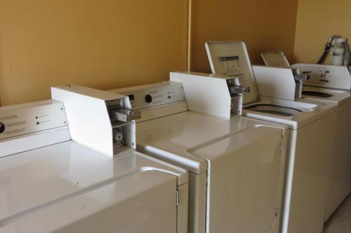 a laundry room with four washers and dryers at Economy Inn & Suites Joplin in Joplin