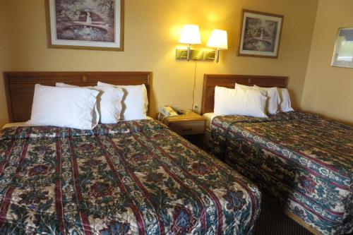 a hotel room with two beds and a phone at Economy Inn & Suites Joplin in Joplin