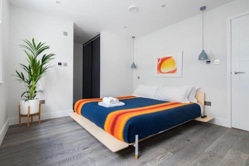 a bedroom with a bed with a colorful blanket at Hausd - Leicester Square in London